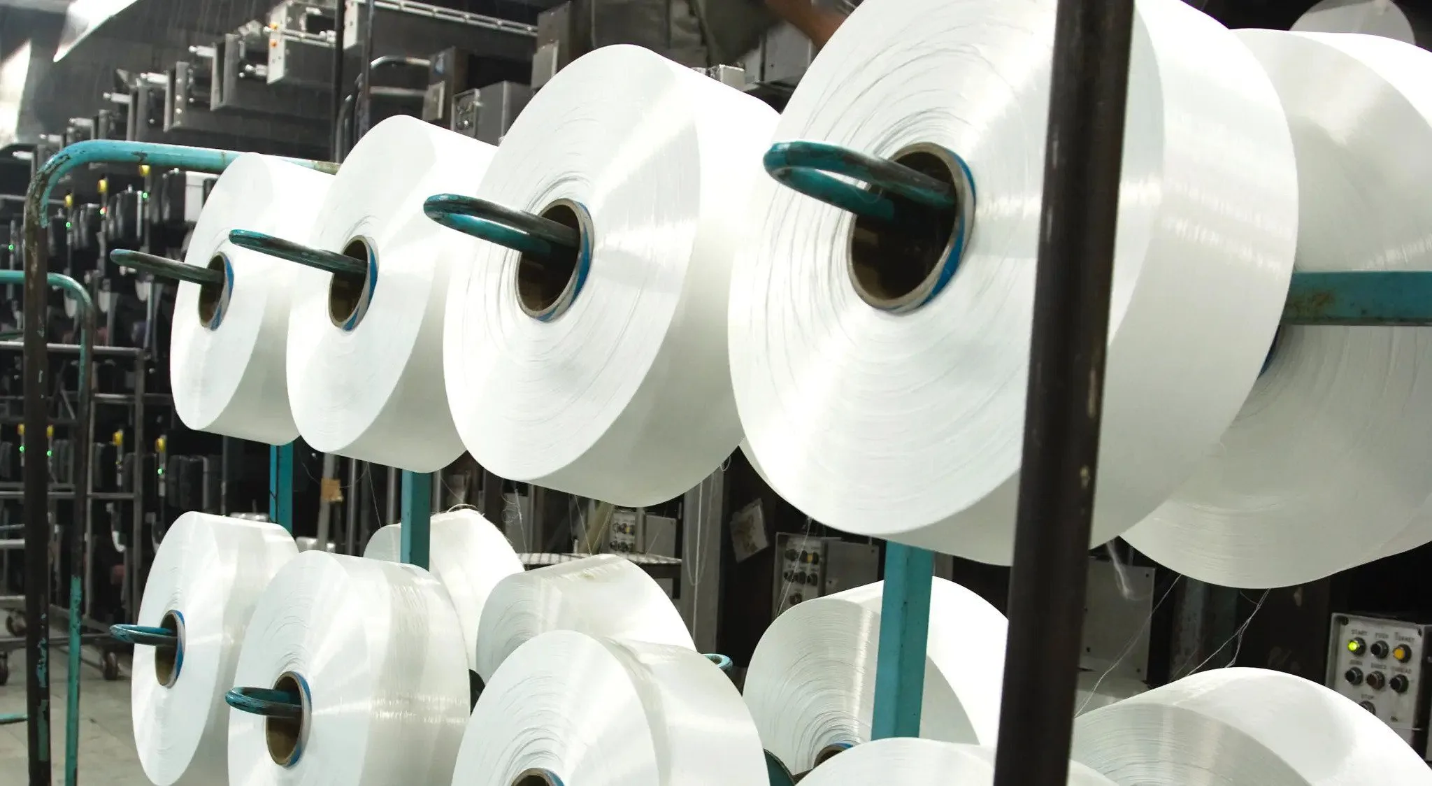 Spools of recycled plastic material sitting in a factory