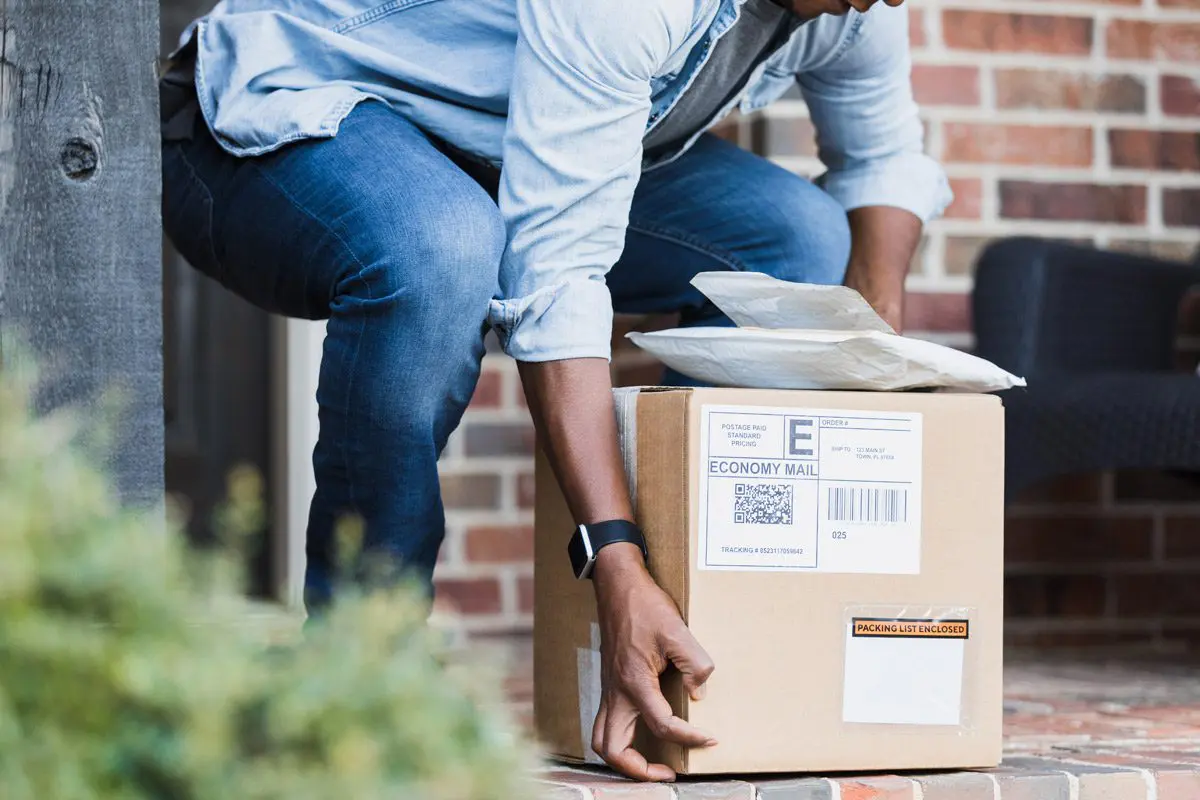Man picking up packages on doorstep..