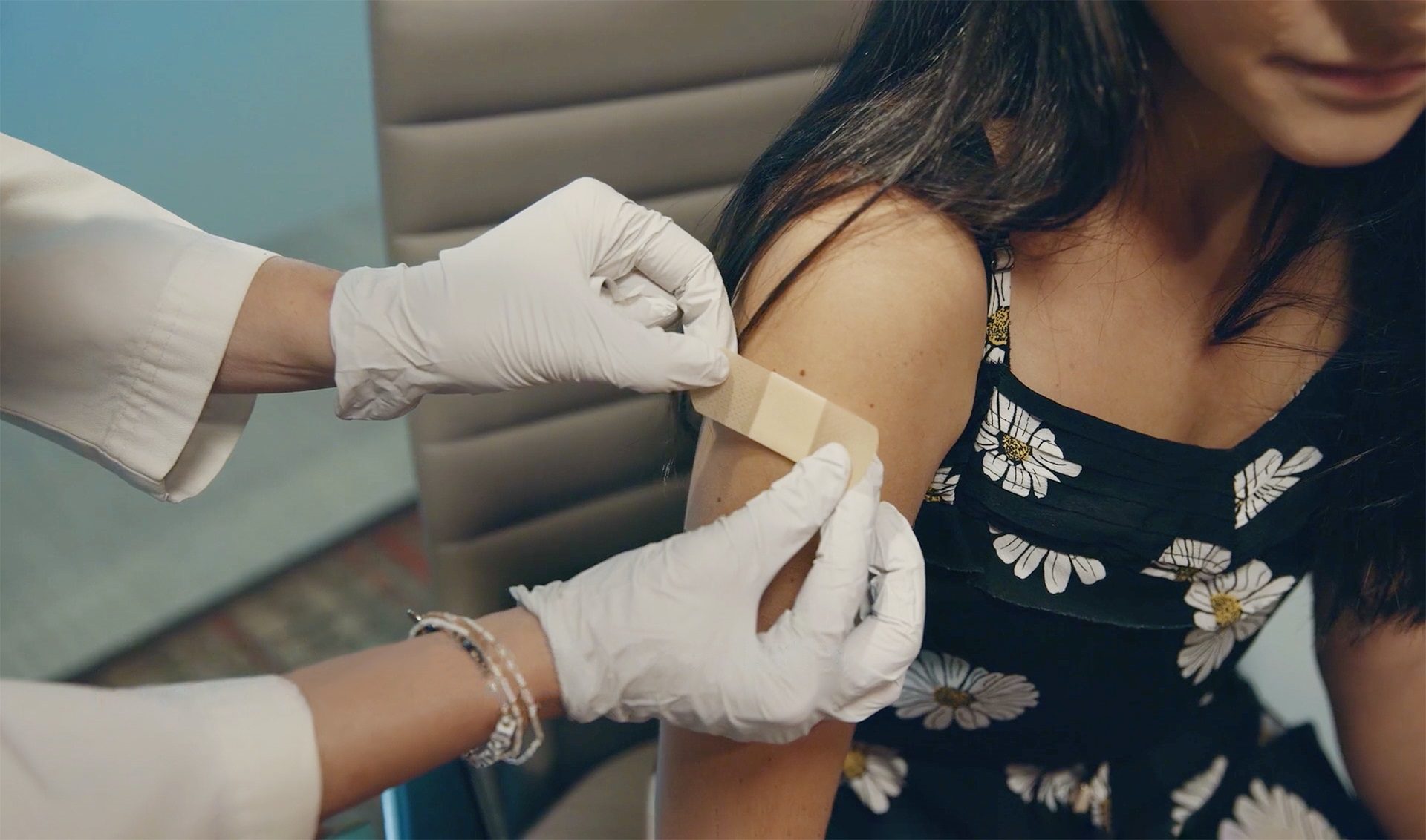 Nurse putting a band-aid on a patient.