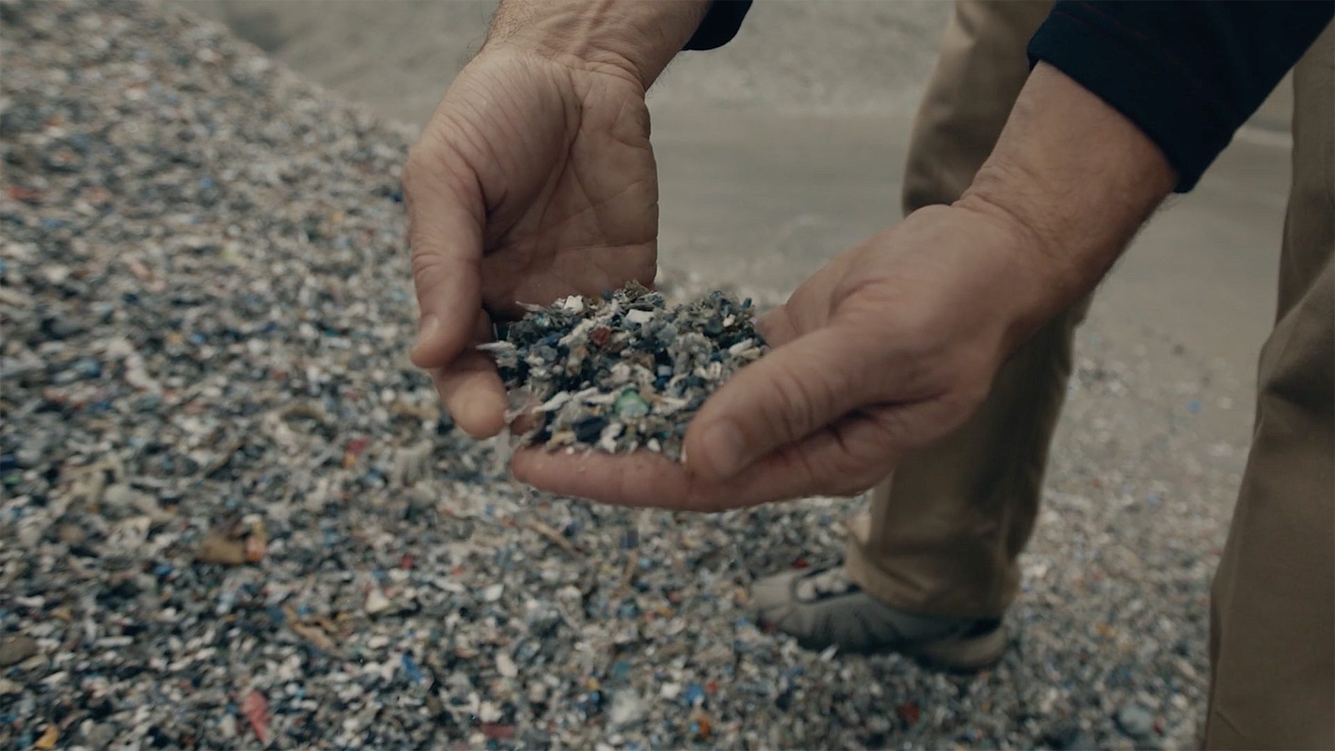 hands holding plastic pellets. 