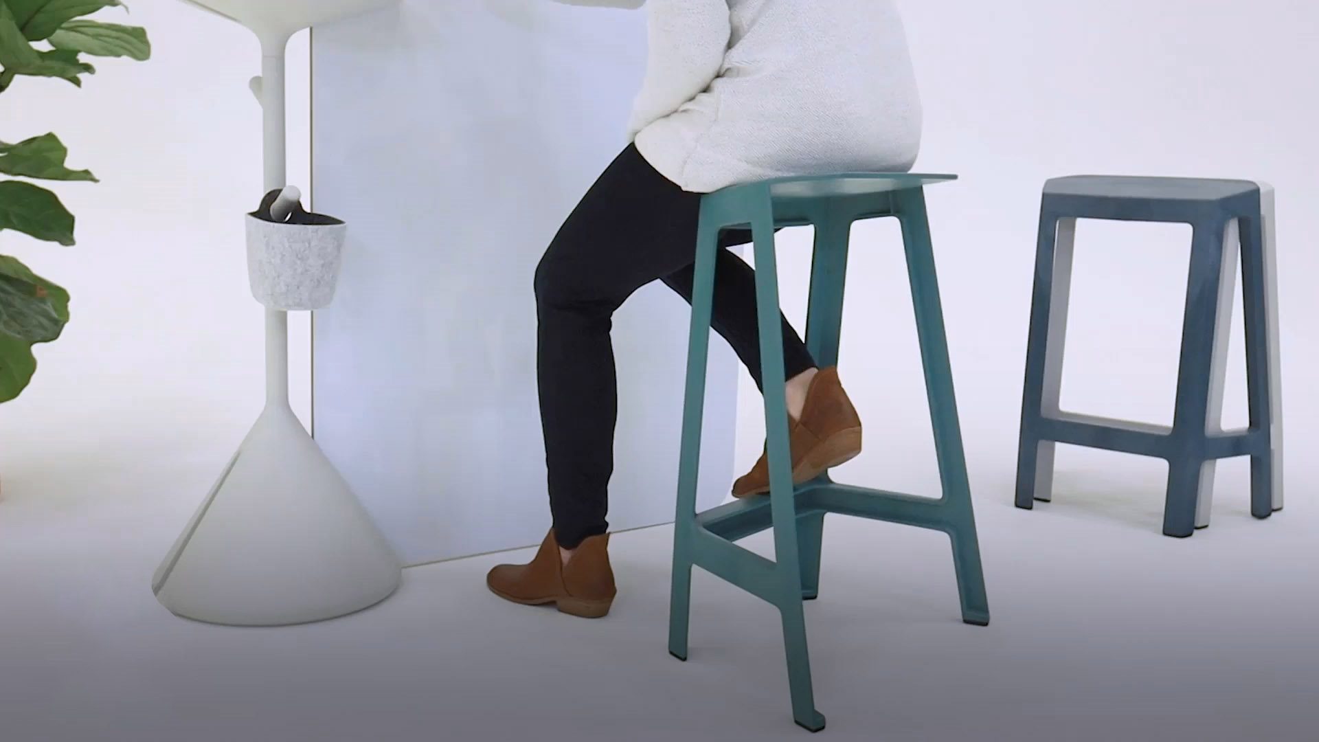 person sitting on blue stool made from waste material that comes from used electronics