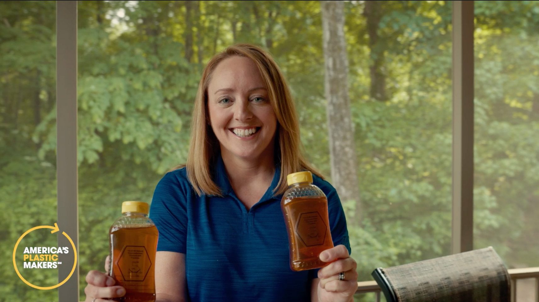 Change Maker Diane Holding Bottles of honey in plastic containers. 