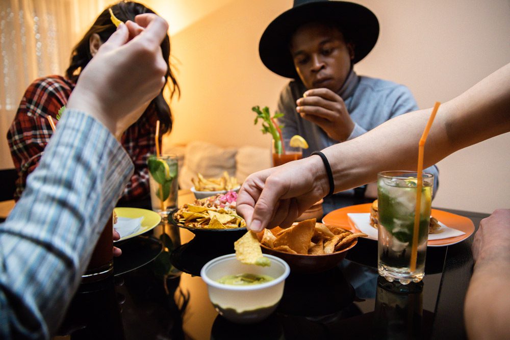 Group eating nachos and drinking cocktails.
