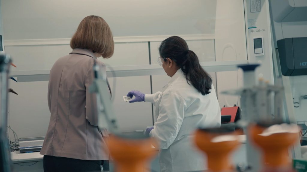Jeanne inspects an object in a lab