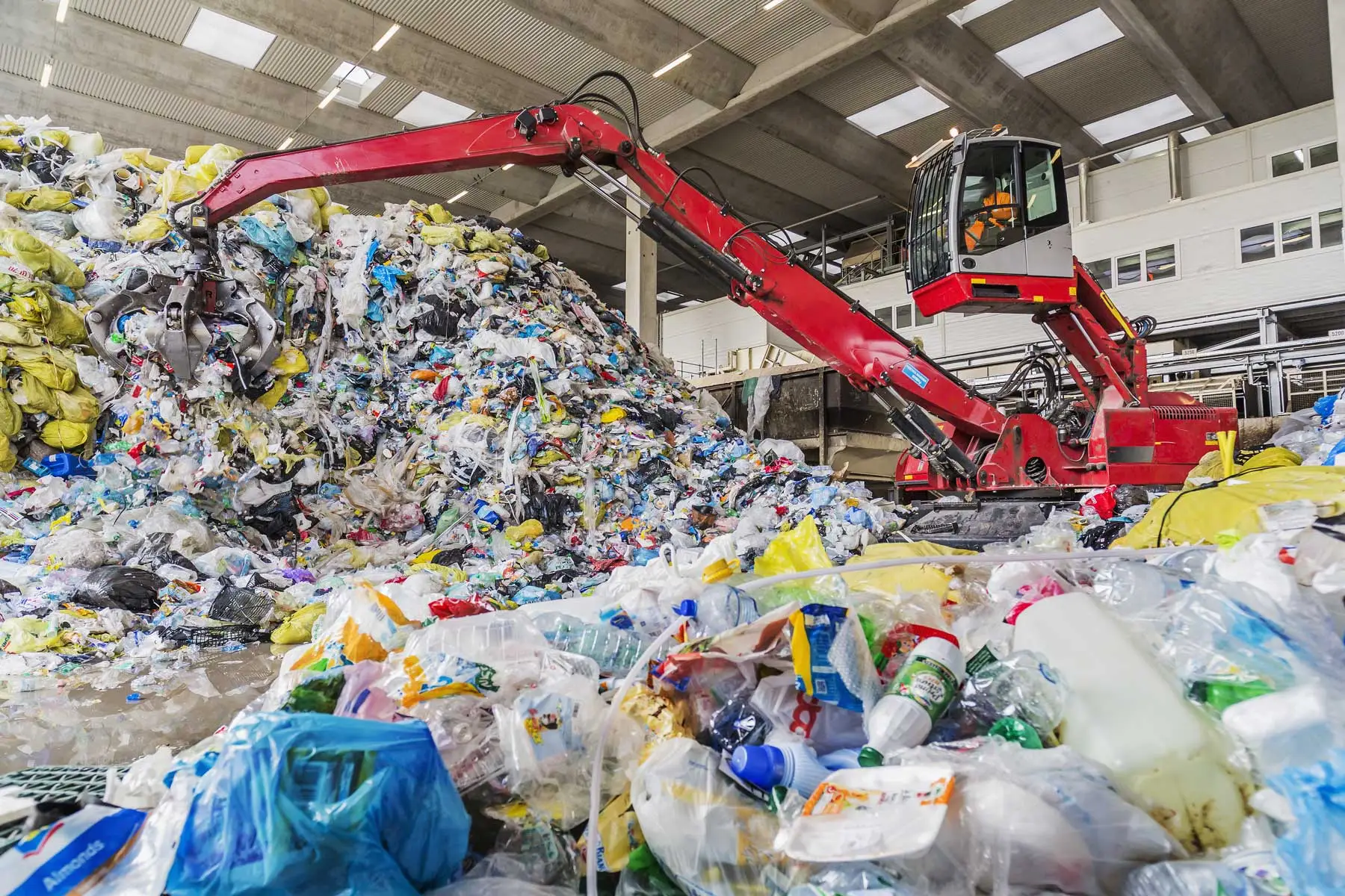 A huge pile of plastic being manipulated with a crane.