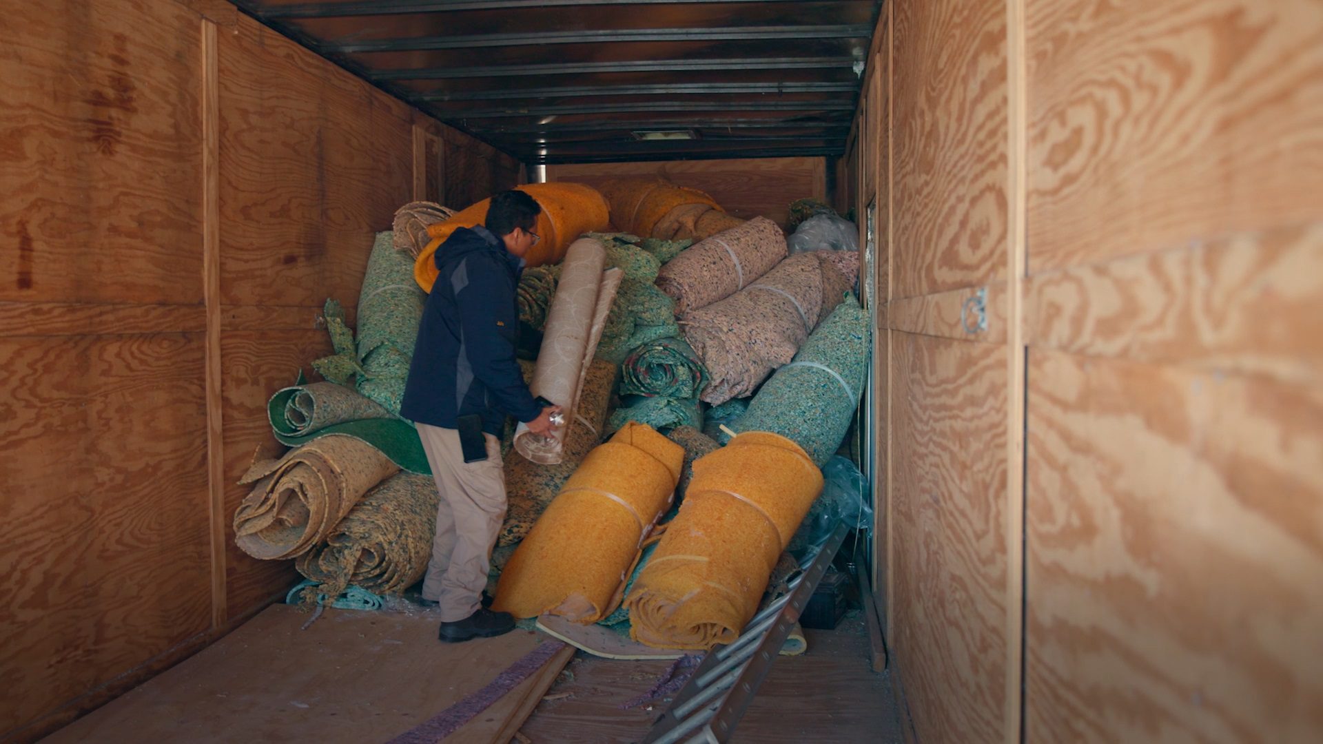 Rolls of fabric piled in the back of a container